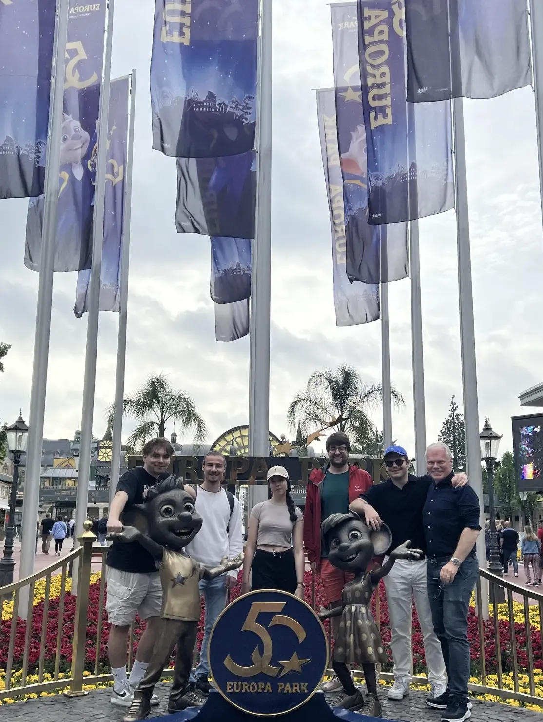 Group photo in front of entrance with flags