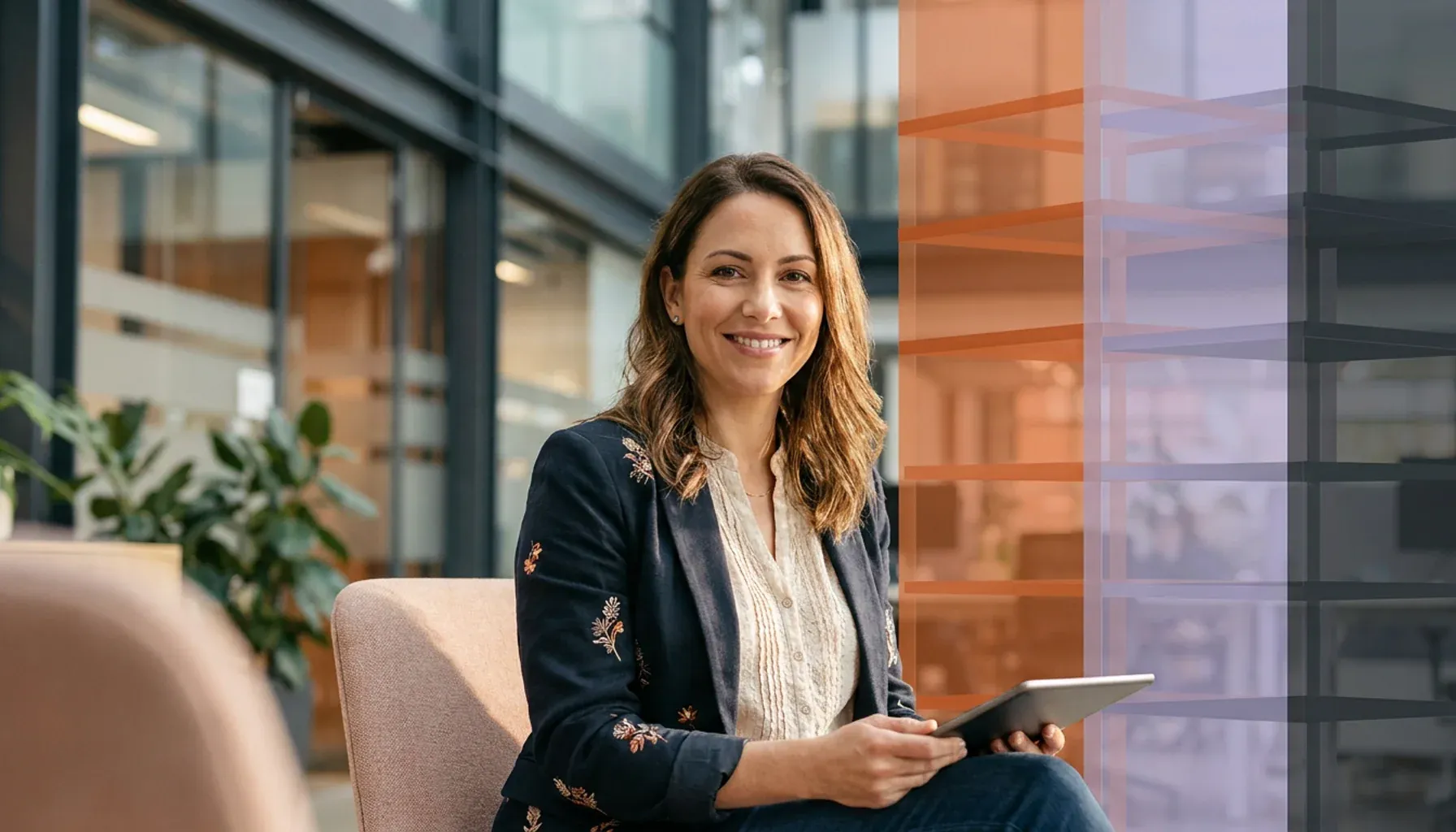 Smiling businesswoman in an office holding a tablet, with abstract colored blocks overlaid.