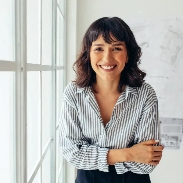 Smiling woman in a striped shirt with her arms crossed.