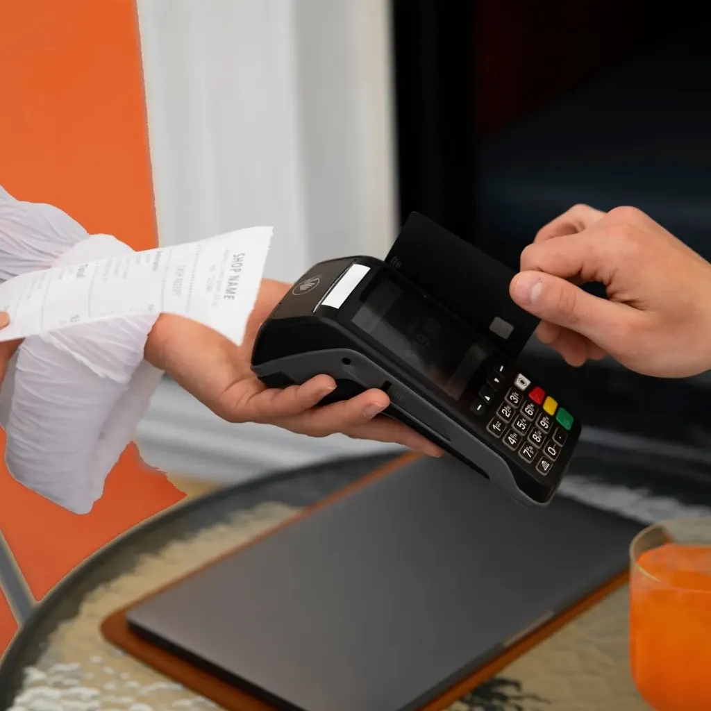 A person taps a credit card on a payment terminal.