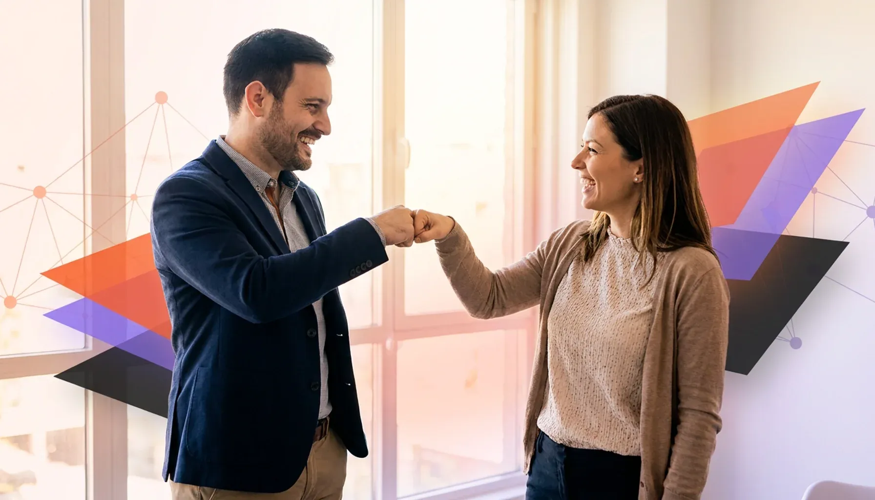 Two smiling colleagues doing a fist bump with abstract geometric graphics in the background.