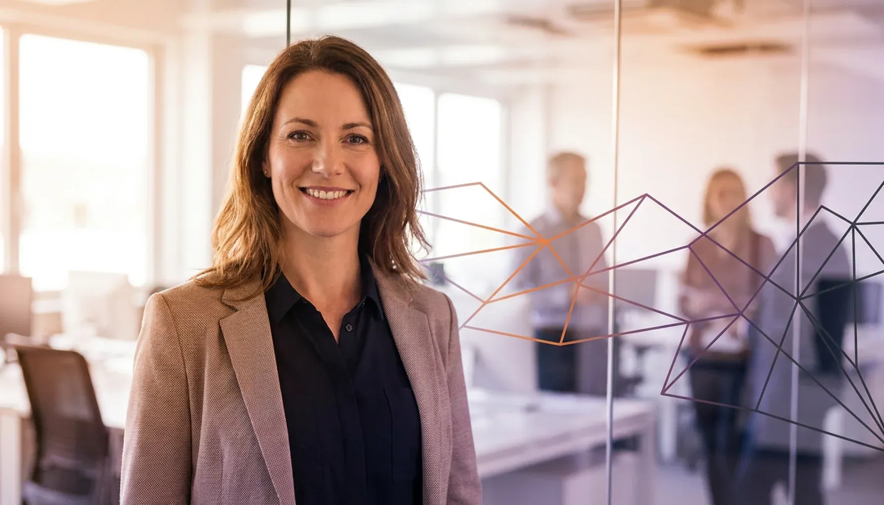 Smiling businesswoman in a modern office with colleagues in the blurred background.