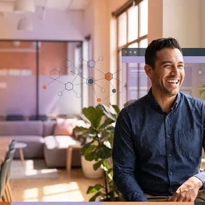 Smiling man talking to a colleague in an office with digital network graphics overlay.