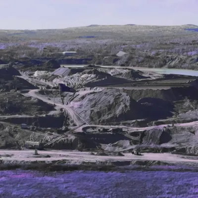 Expansive landscape of an open-pit mine with excavation paths and machinery