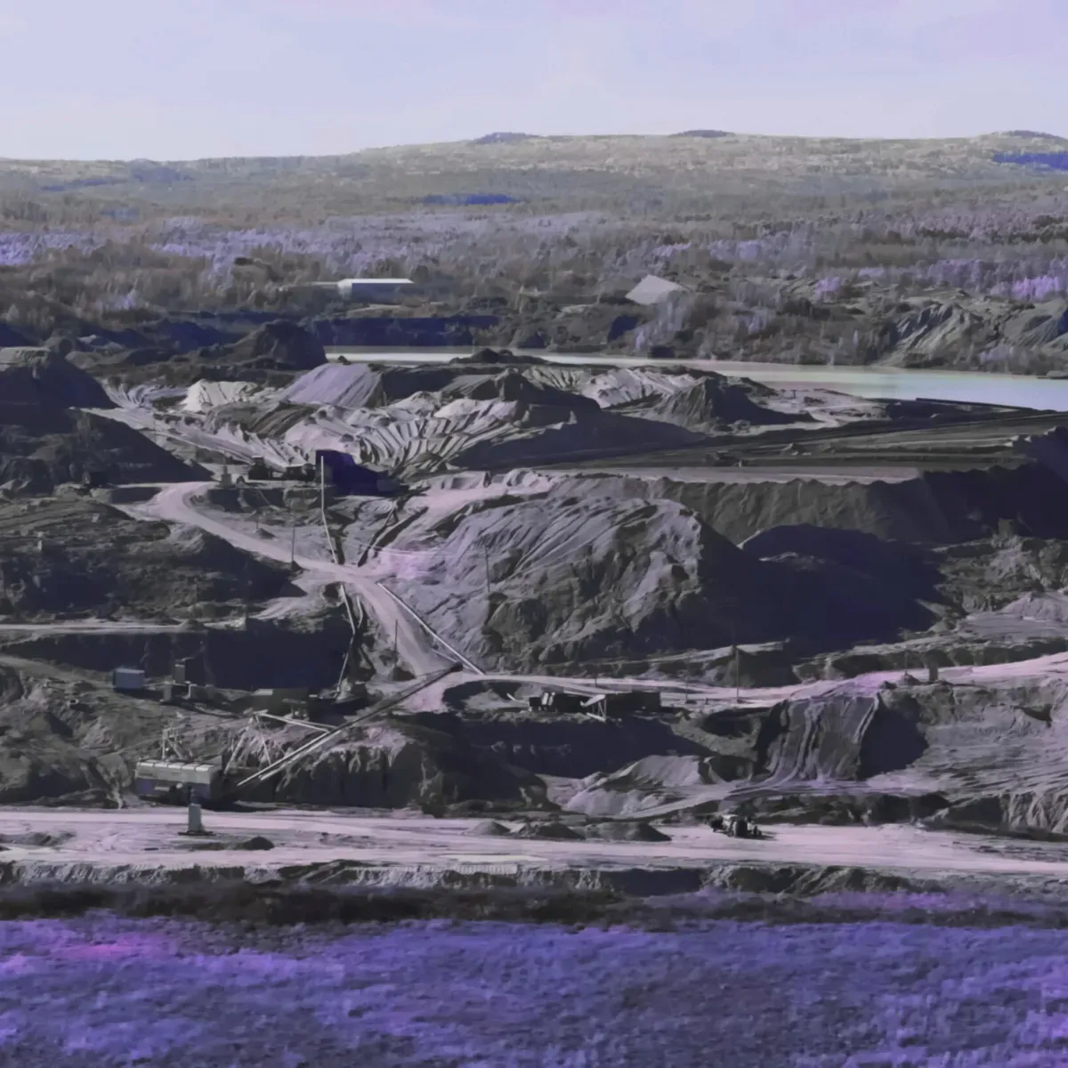 Expansive landscape of an open-pit mine with excavation paths and machinery