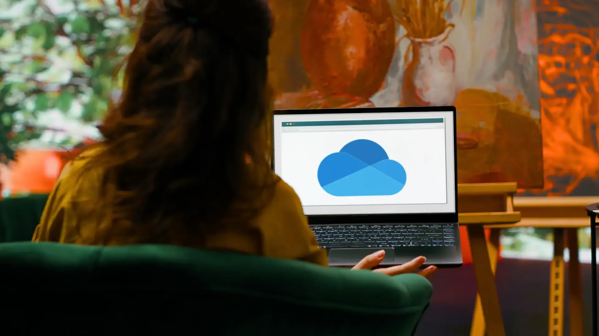 Eine Person betrachtet einen Laptop mit einem blauen Cloud-Symbol.