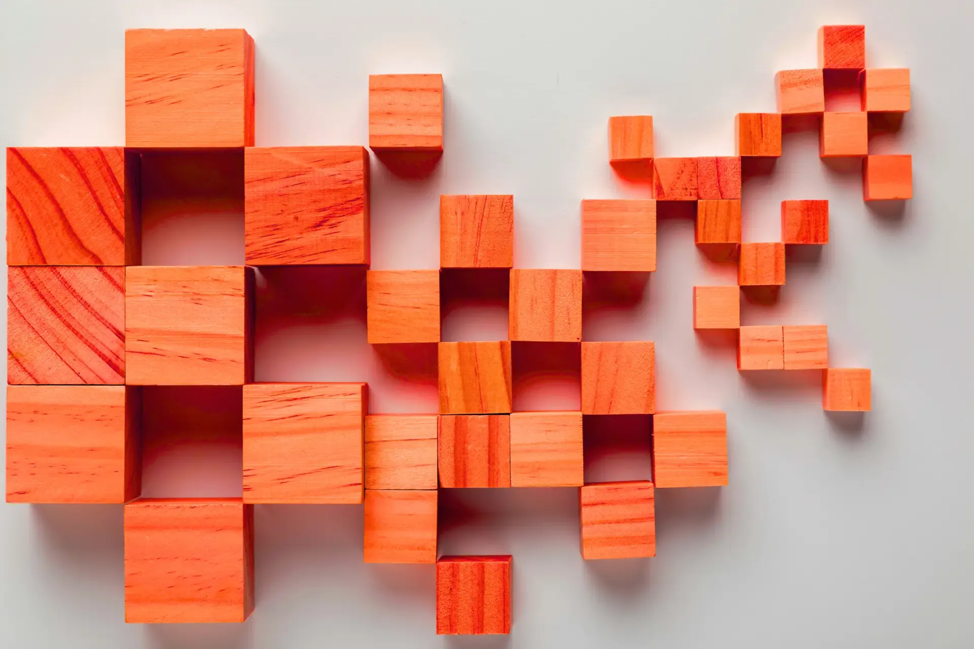 Orange wooden blocks arranged in a pixelated pattern on white.