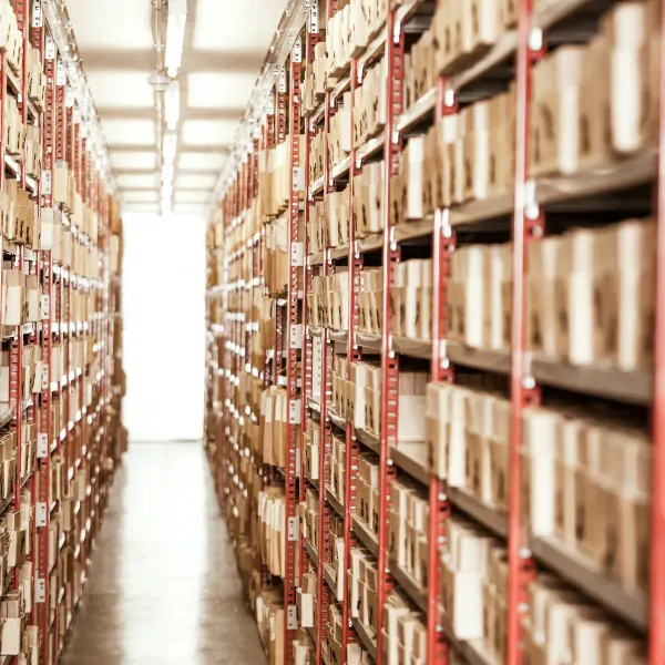 Langer Gang mit hohen Regalen voller Akten und Archivboxen in einem Archivlager