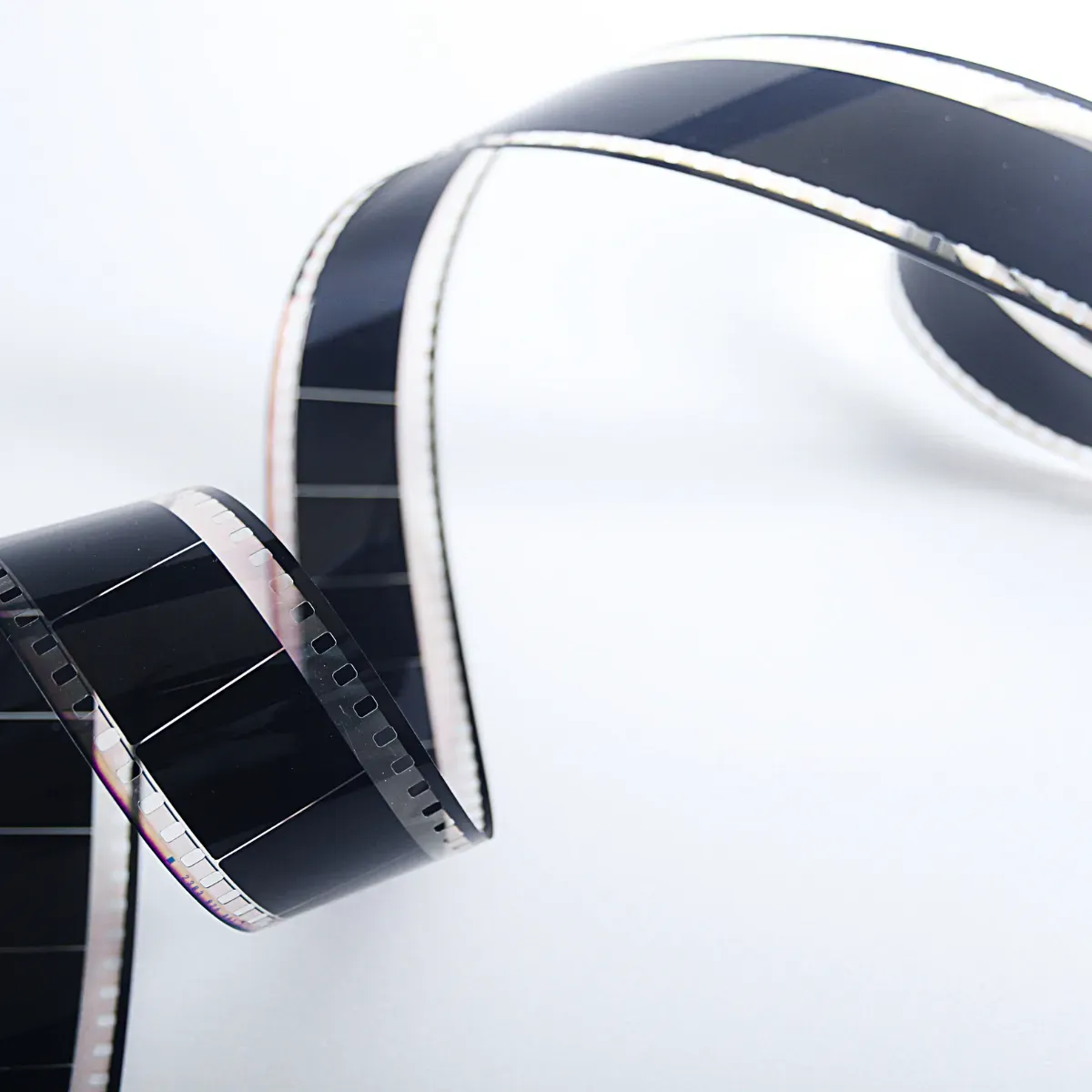 Close-up of a black translucent film strip in a curved shape on a bright background
