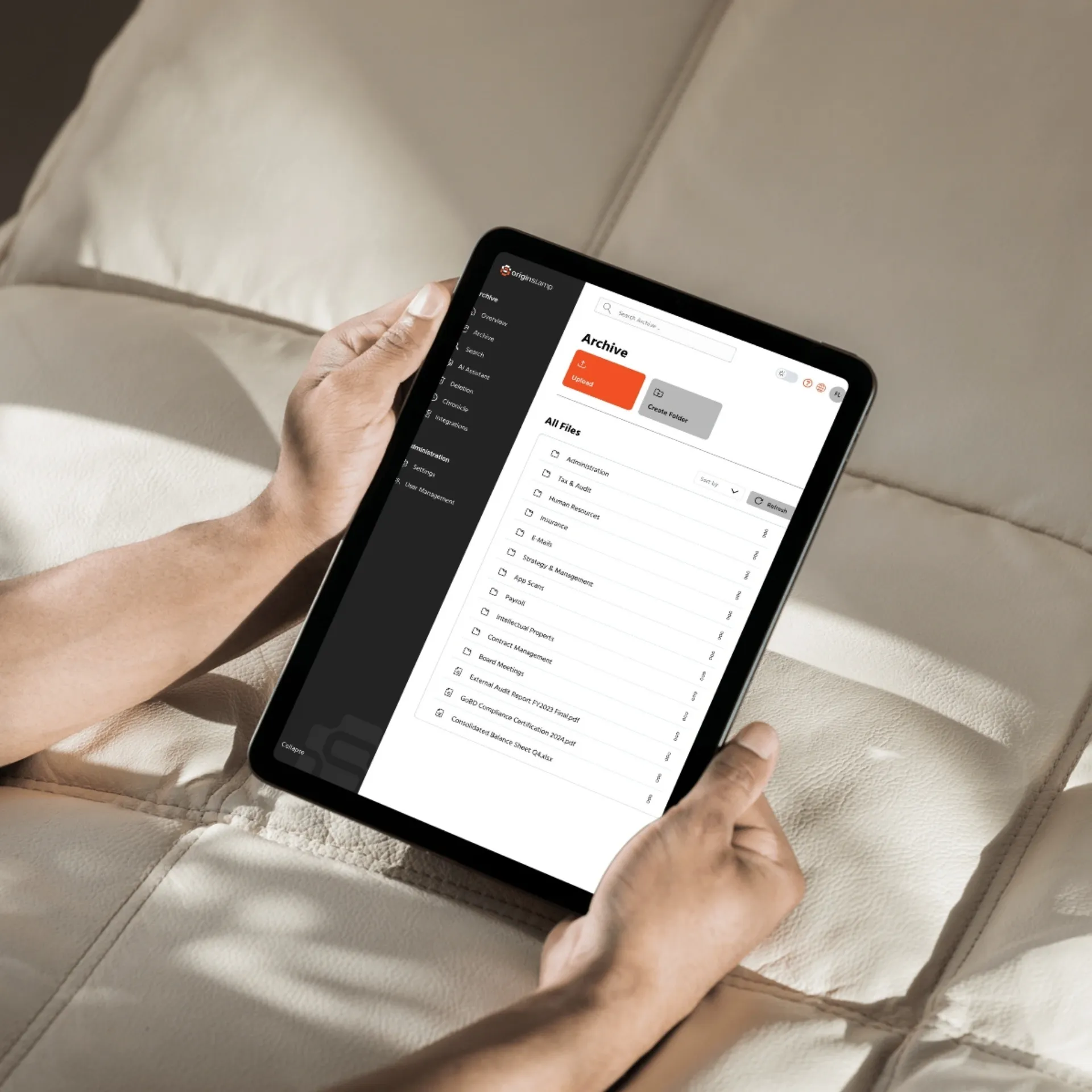 A person holds a tablet showing a digital file archive application.
