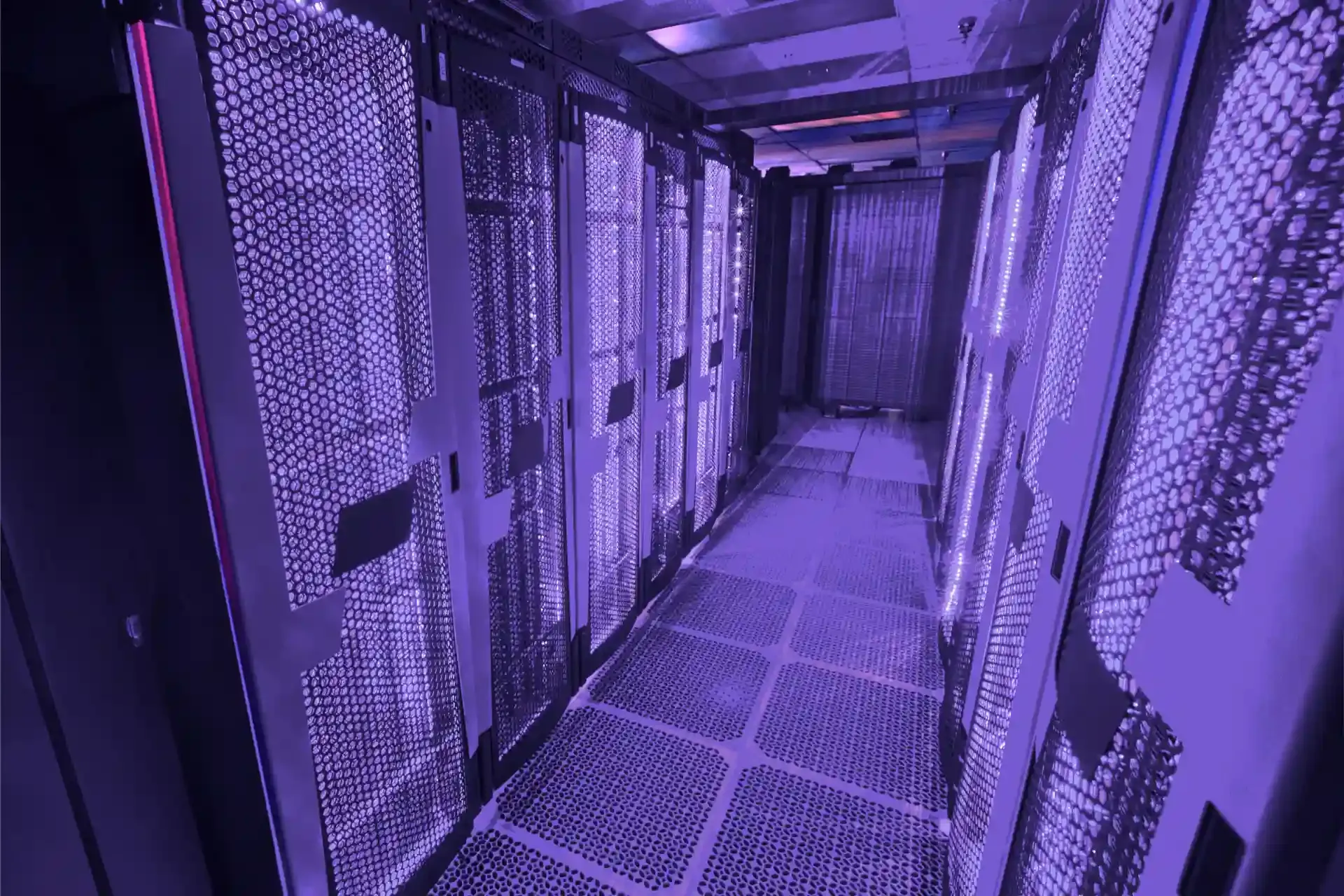 Moderner Serverraum mit beleuchteten Rack-Reihen und violettem Licht.
